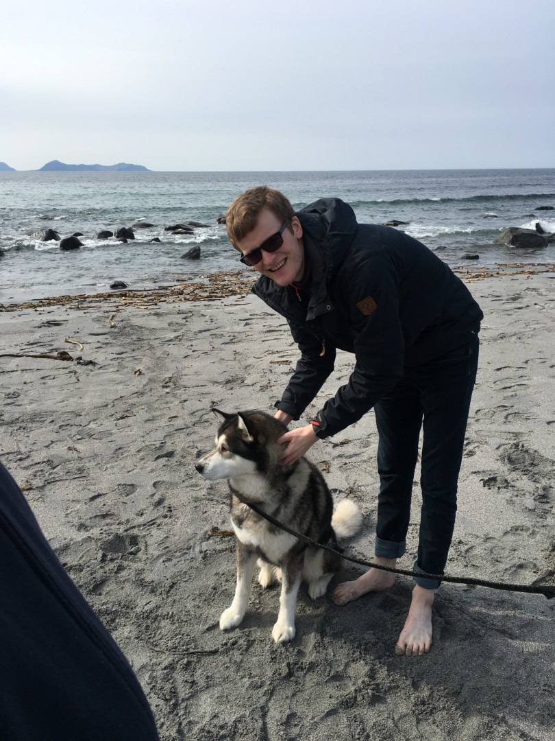 Mann på stranden med hunden sin
